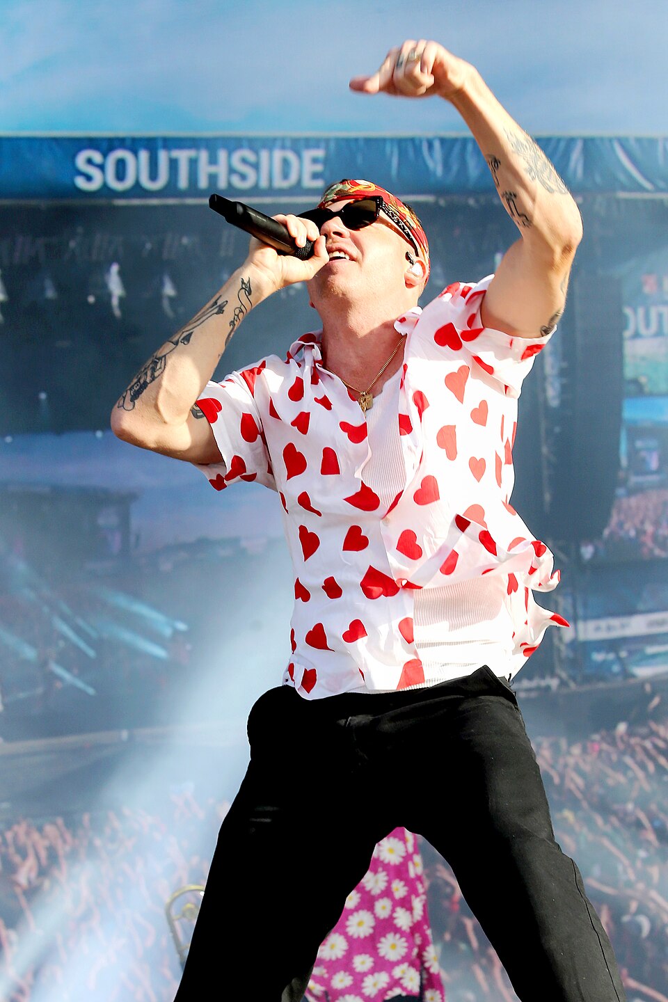 Macklemore performs with a microphone and one arm raised at Southside Festival on June 23, 2019. File photograph.