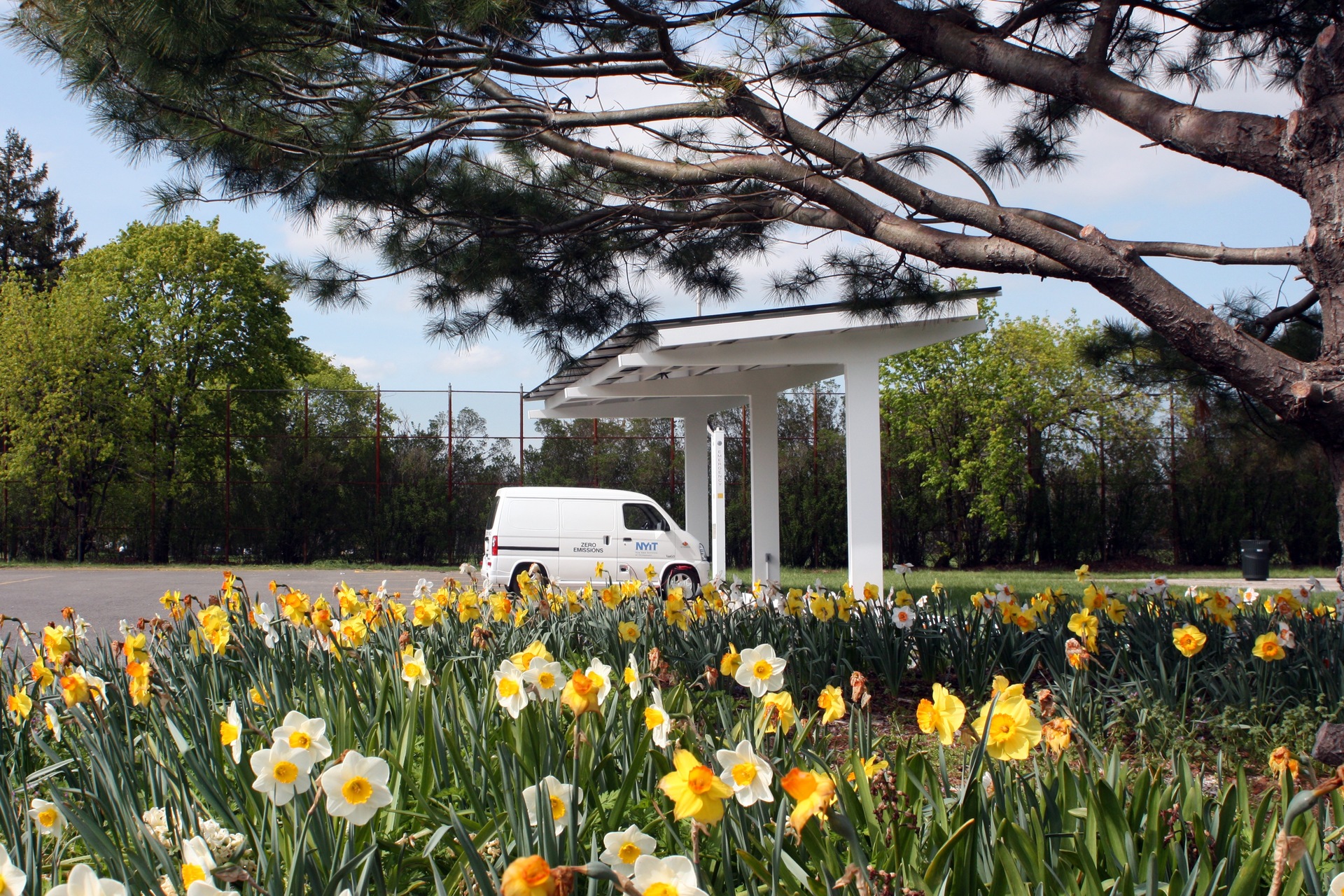 An electric van beneath a solar charging canopy at New York Institute of Technology in May 2009. Historical technology context, not a Bakersfield installation.