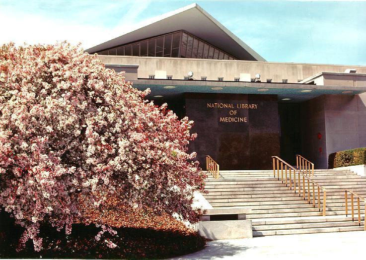 The National Library of Medicine building in Bethesda, Maryland, viewed across a lawn.