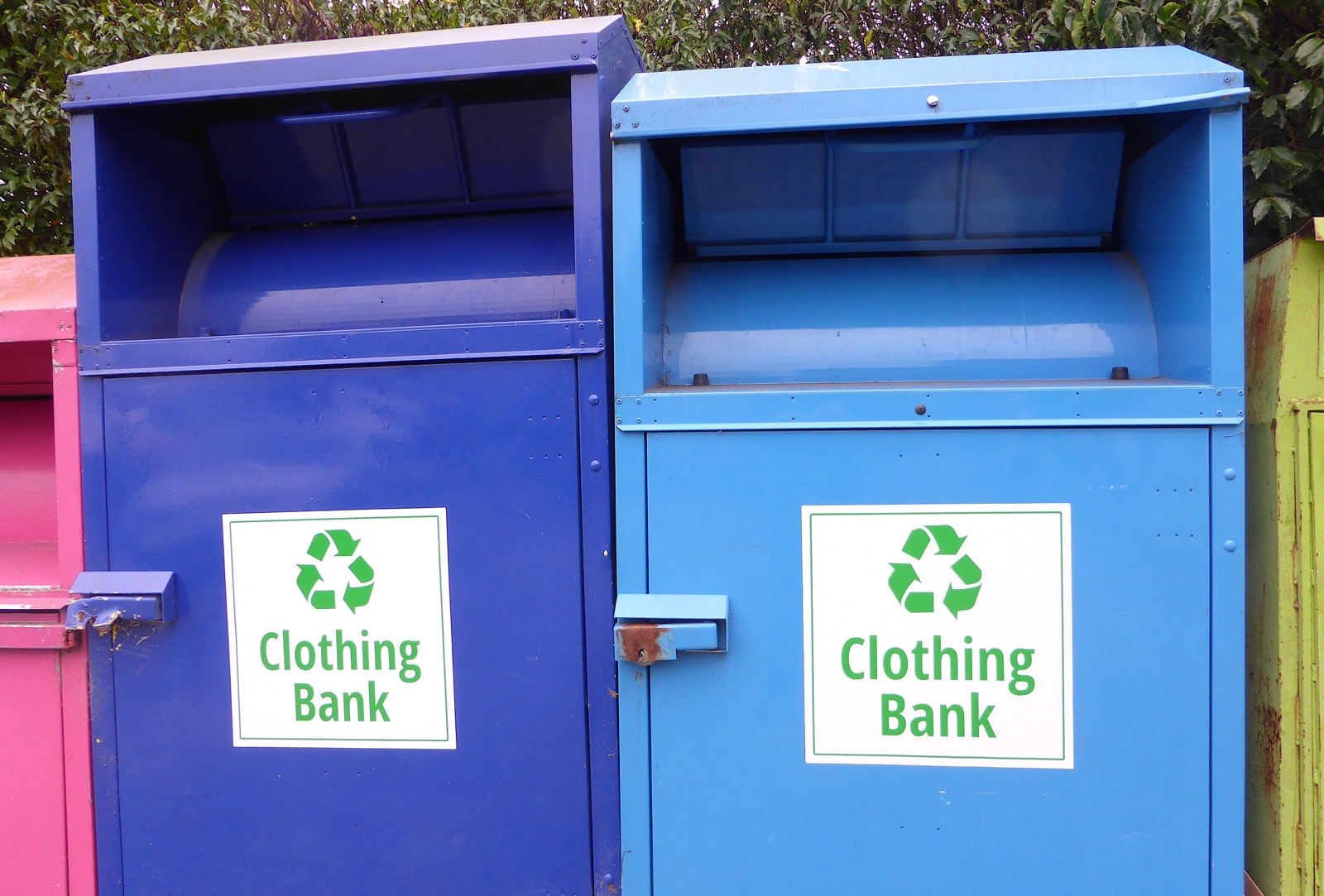 Blue and purple clothing-bank collection bins, photographed November 9, 2024. Source does not identify location. Illustrative textile-collection context, not California program results. Digitura/Wikimedia Commons, CC0 1.0.