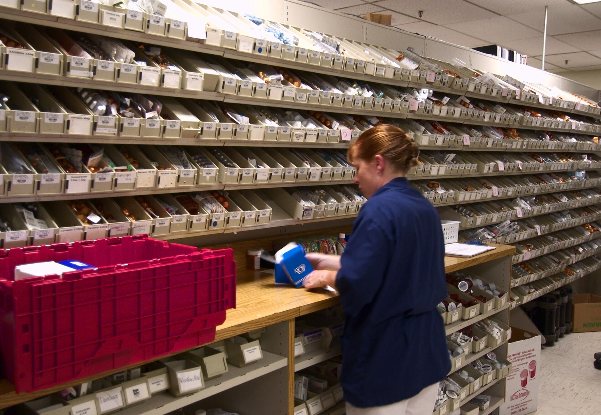 A Navy hospital corpsman restocks medication at the National Naval Medical Center in Bethesda, Maryland, in August 2003. Historical pharmacy context; this is not a Medicare enrollee or a 2027 plan provider. Photo: Chief Warrant Officer 4 Seth Rossman / U.S. Navy / Public domain.