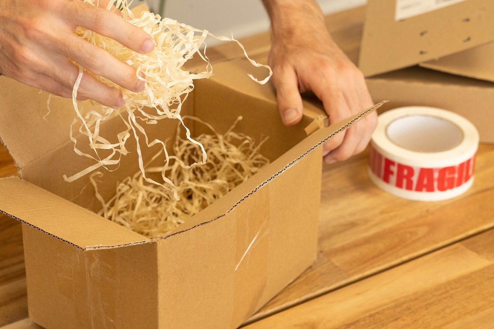 A cardboard box being packed with wood wool in June 2022; shipping context, not a disputed purchase or a named retailer's return.