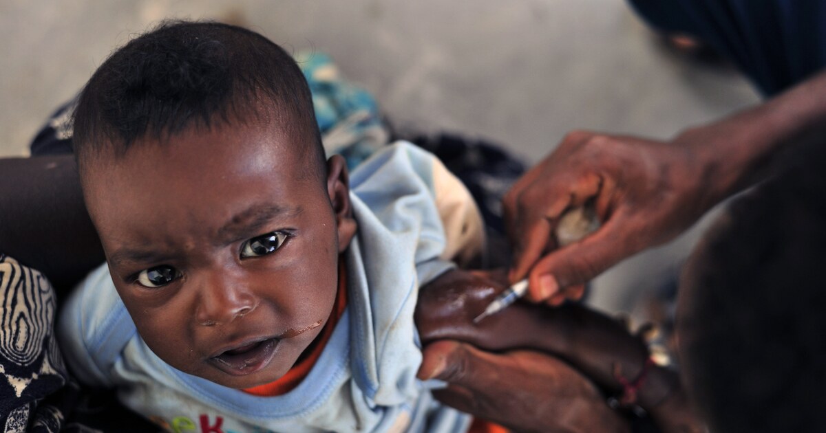A child receiving a vaccination from a health worker